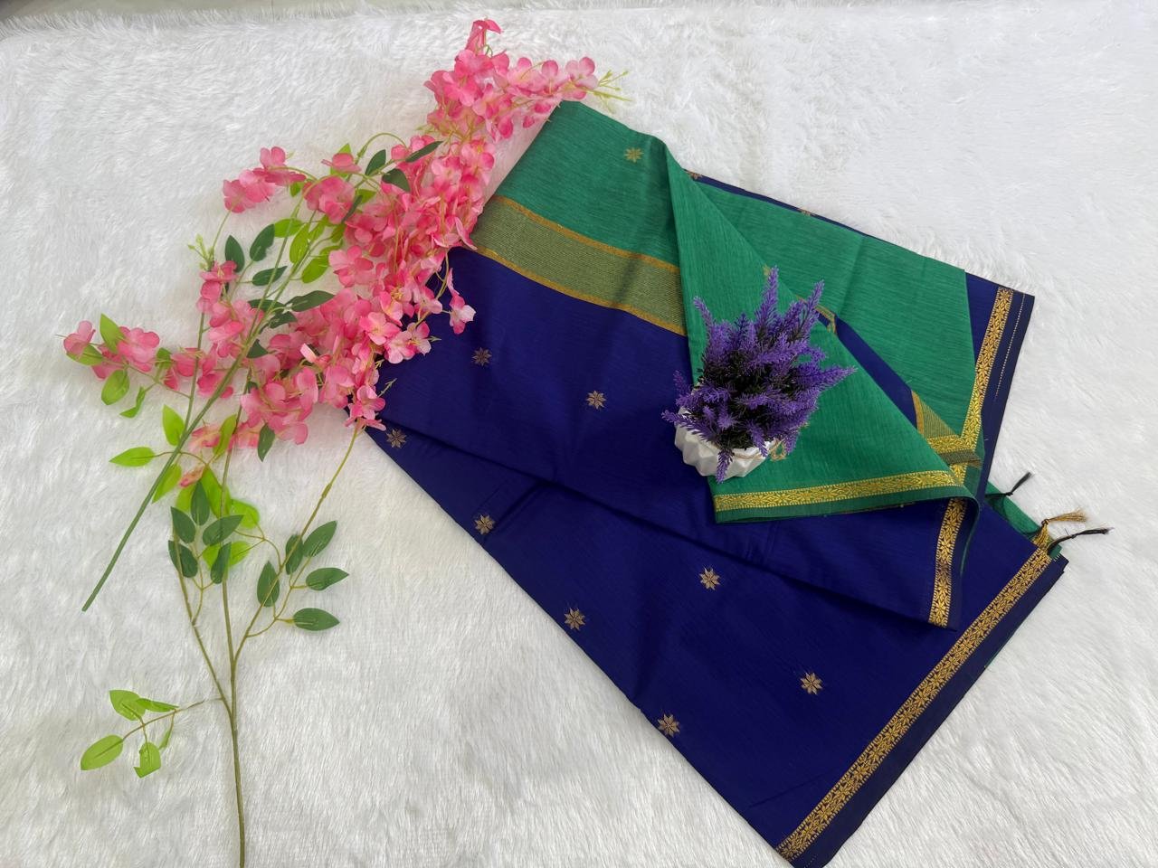 Royal blue saree featuring gold star motifs with a contrasting leaf green pallu and gold zari border.