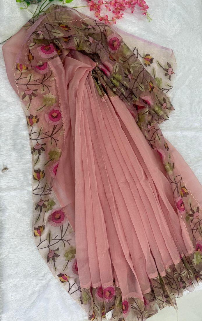 Sheer blush pink saree featuring a scalloped border with pink floral vine embroidery.